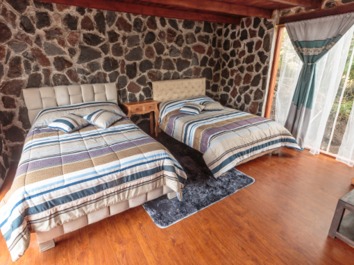 Family and Friends Room with private bath Cozy guest room at Tambo Cóndor with two queen beds, warm bedding, and private bath in the Ecuadorian Andes.