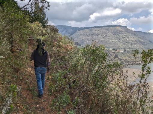 Vladimir leading a personalized, guided tour | ©Angela Drake Vladamir, with spotting scope on his shoulder, walks a trail on his land at Tambo Condor.